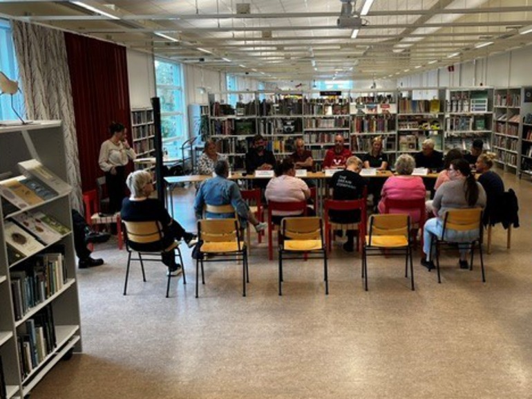 grupp med människor i biblioteksmiljö