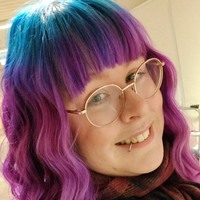 Kvinna med blått och lila hår och glasögon