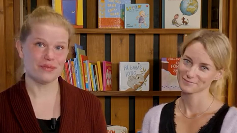 två kvinnor framför en bokhylla med småbarnsböcker